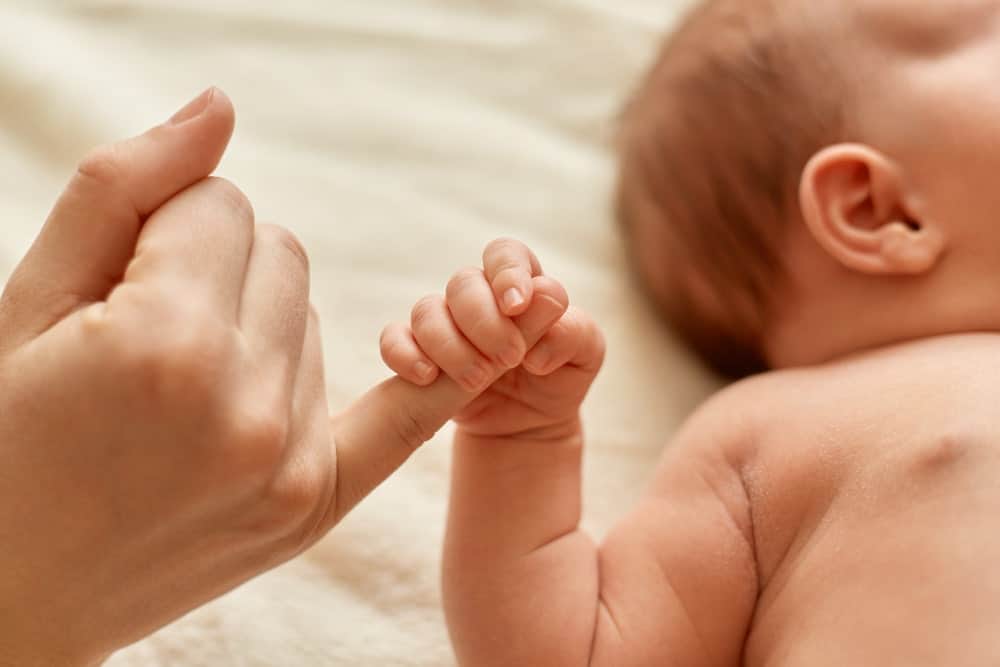 bebe sujetando dedo madre